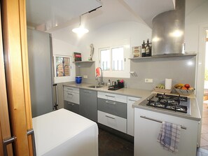 A compact kitchen with a gas stove, a dishwasher, and a refrigerator. - House with sea view, pets allowed - 8 guests (Llançà)