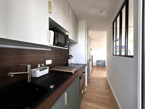 Eine moderne Küche mit Mikrowelle, Spüle und einer Holz Arbeitsplatte.