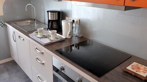 Une cuisine moderne équipée d’un évier, d’une machine à café et d’une bouilloire électrique.