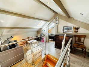 Une pièce de style loft avec un escalier, un canapé, un bureau et un lit.
