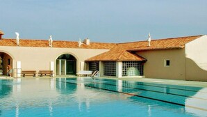A swimming pool with clear water, surrounded by buildings with tiled roofs and white statues. - Mobile home, pets OK, AC - 6 guests (Verteillac)