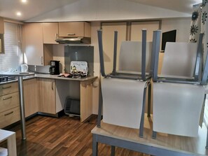 Une cuisine compacte équipée d’une cuisinière à gaz, d’une machine à café et d’un grille-pain.