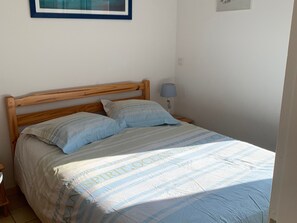 A single bed with a wooden headboard, two pillows, a bedside lamp, and a framed picture on the wall. - House near beach, pets welcome - 4 guests (Saint-Hilaire-de-Riez)