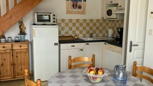 A kitchen with a microwave, a refrigerator, a sink, and a dining table with chairs. - House near beach, pets welcome - 4 guests (Saint-Hilaire-de-Riez)