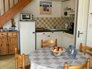A kitchen with a microwave, a refrigerator, a sink, and a dining table with chairs. - House near beach, pets welcome - 4 guests (Saint-Hilaire-de-Riez)