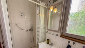 A bathroom with a shower, a sink, a mirror, and a window. - Central studio, pets welcome - 2 guests (Blois)