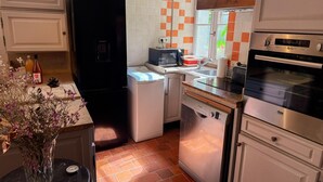 A compact kitchen with a black refrigerator, a microwave, a dishwasher, and a stove. - Central studio, pets welcome - 2 guests (Blois)