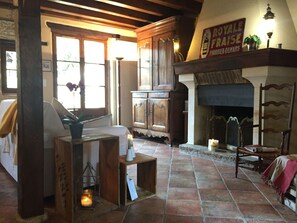 A cozy room with a fireplace, wooden furniture, and a sign reading "ROYAL FAYLE FOURNIER DENARS". - Cozy lodging in city center - 8 guests (Saint-Amand-Montrond)