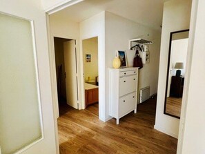 A hallway with wooden flooring, a white dresser with drawers, a mirror, and a radiator. - Apartment with garage, pets allowed - 4 guests (Amélie-les-Bains-Palalda)