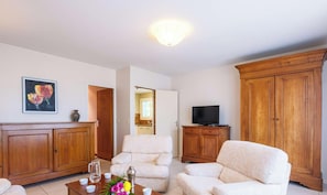 A living room with a television, wooden cabinets, and a sofa. - Family home in the city center - 8 guests (Biscarrosse)