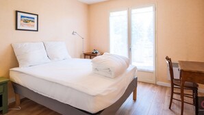 A bedroom with a bed, a desk, a chair, a lamp, and a window. - Family home in the city center - 8 guests (Biscarrosse)