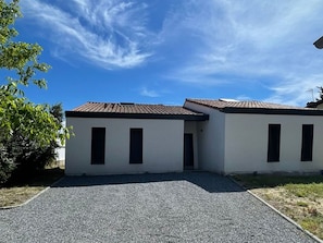 A two-story building with a flat roof, rectangular windows, and a gravel driveway. - House with parking and garden - 4 guests (Capbreton)