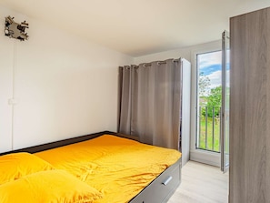 Une chambre à coucher avec un lit, une fenêtre et une vue sur la verdure.