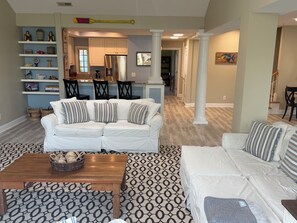 A living room with a white sofa, patterned rug, and a wooden coffee table. - Waterfront 3-bd, 2bath, boat slip, remodeled 2171 sq ft, ocean views & pool (Carolina Beach)