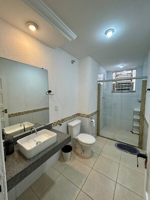 A bathroom with a sink, toilet, and shower.
