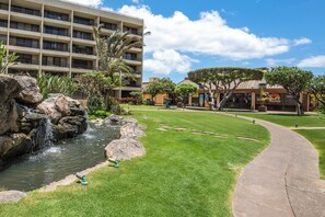 A hotel with a swimming pool, a waterfall, and a well-maintained lawn. - Sugar Beach Resort 232, Oceanfront Ocean View, Central A/C (Kihei)