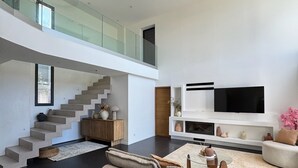 A modern living room with a staircase, a flat-screen TV, and a sofa. - TOULON ARCHITECT-DESIGNED VILLA (Toulon)