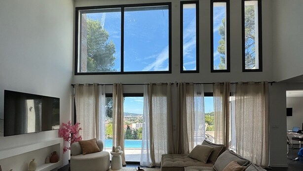 A spacious living room with a large window, a flat-screen TV, and a sofa. - TOULON ARCHITECT-DESIGNED VILLA (Toulon)