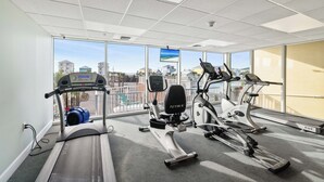 Academia com esteiras, elípticos e bicicleta ergométrica.