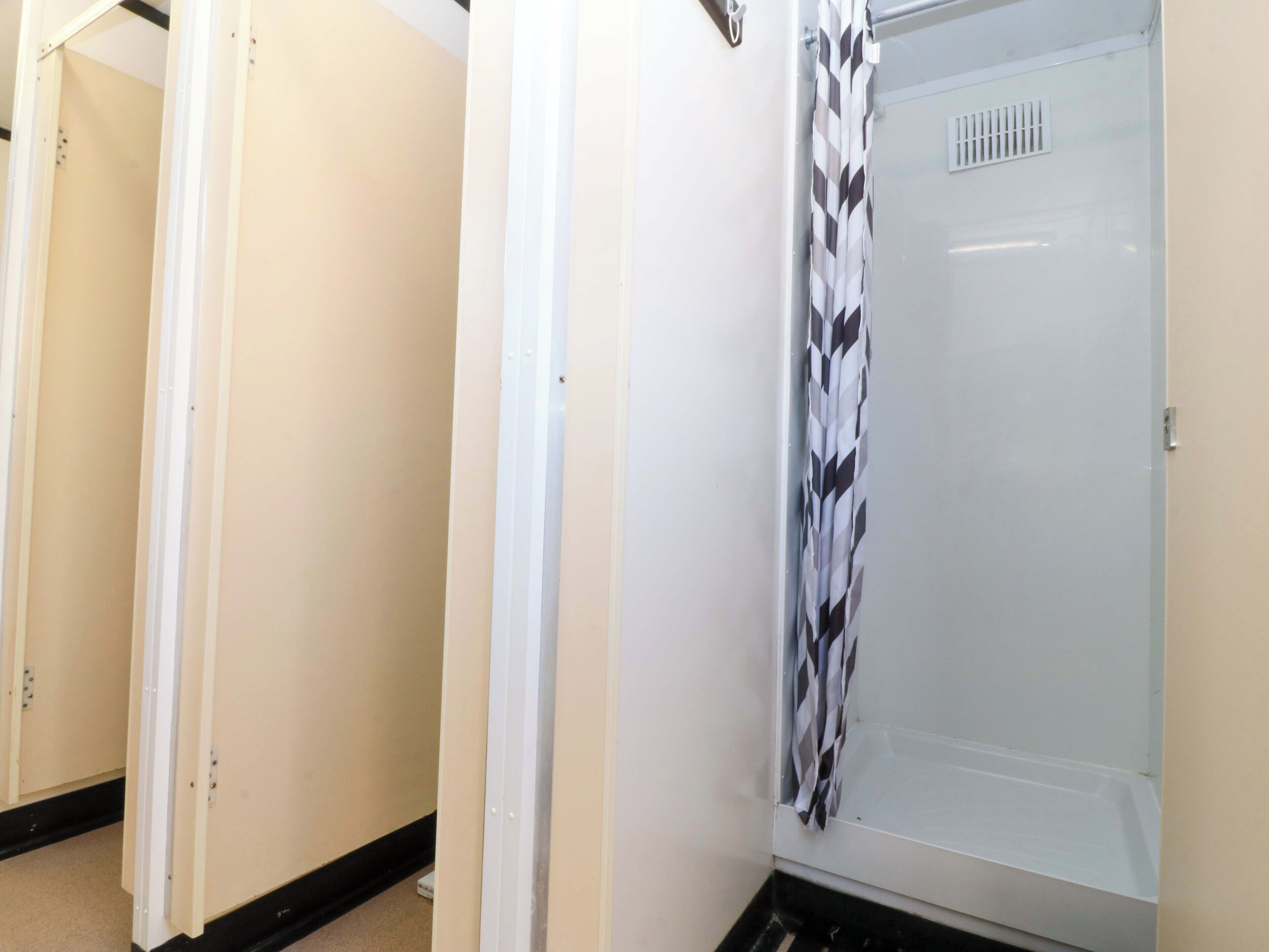 A bathroom with a shower, a toilet, and a sink.