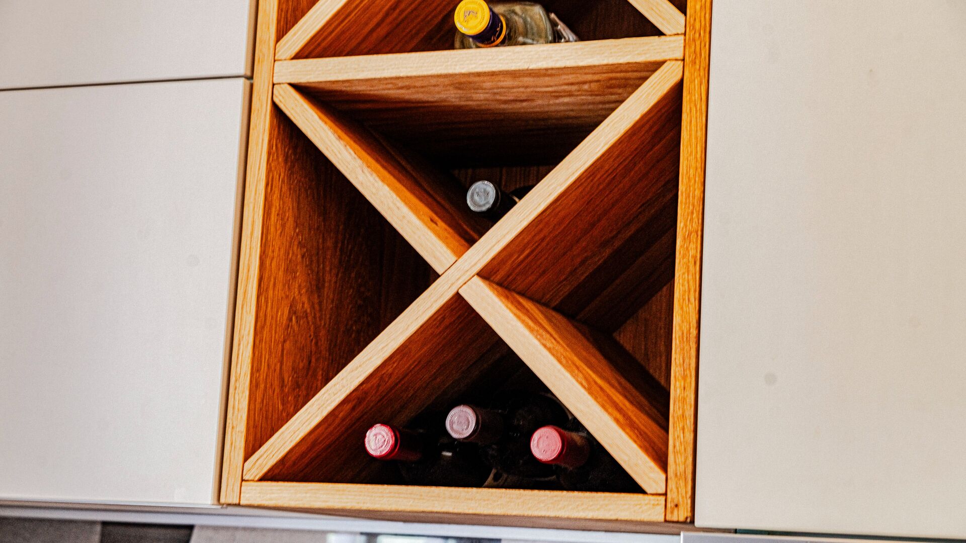 A wooden wine rack with bottles inside.