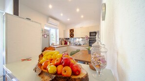 Una cocina con un frutero, un tarro de vidrio y una ventana.