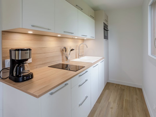 Eine moderne Küche mit Kaffeemaschine, Spüle und Holzausbau.