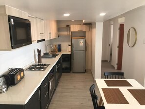 A modern kitchen with a microwave, stove, sink, and refrigerator. - Oceanview Family Retreat in Vi a Laundry Parking (Vina del Mar)