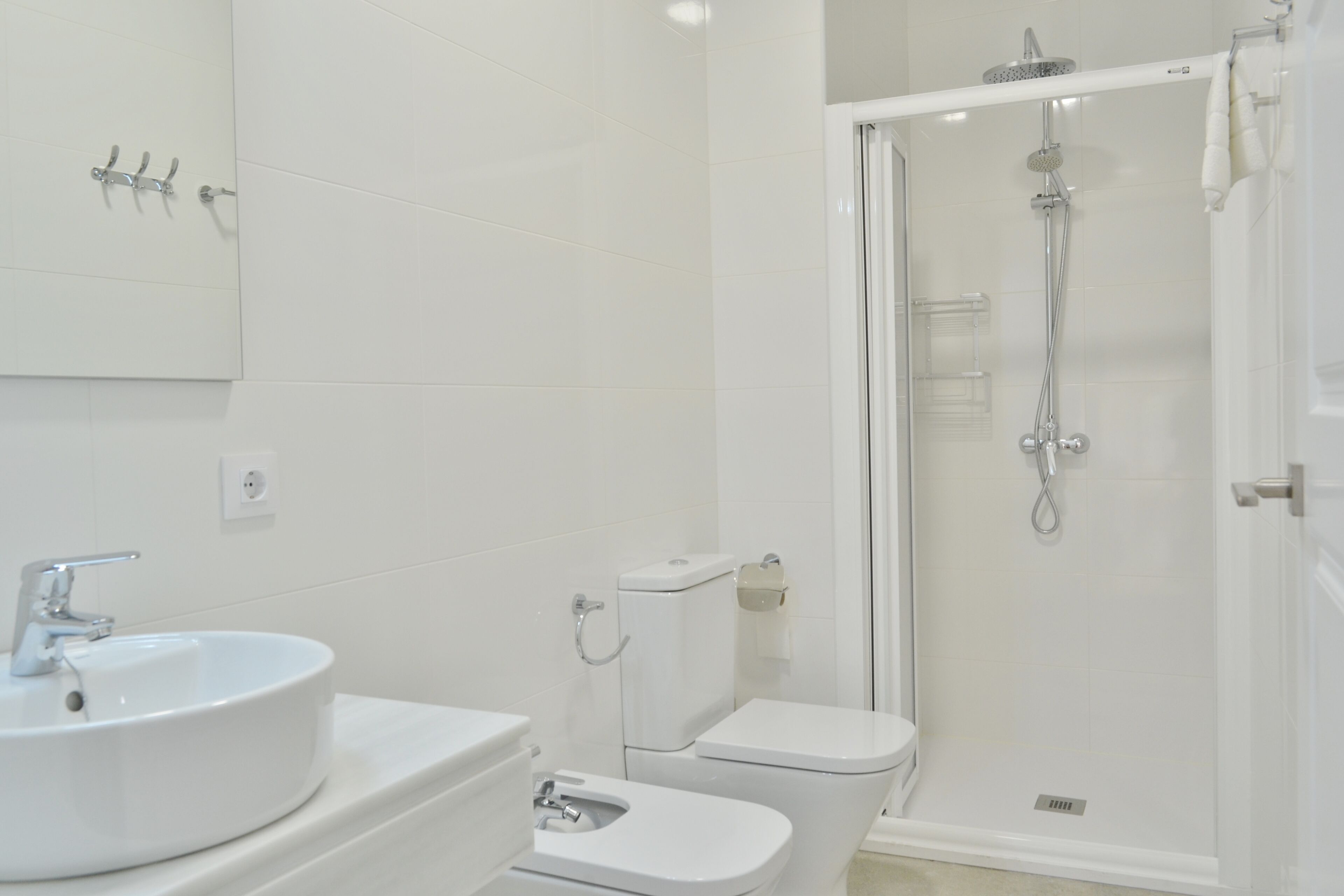 Un baño con lavamanos, inodoro y ducha.