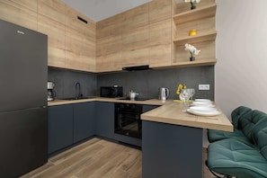 A modern kitchen with wooden cabinetry, a built-in oven, and a wooden countertop.