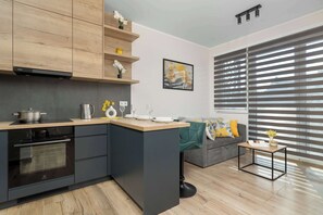 Una cocina moderna con horno empotrado, encimera de madera y una isla gris.