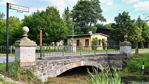 A stone bridge over a water body with a small building on the other side. - Cozy accommodations on Lake Oberuckersee for larger groups (Flieth-Stegelitz)