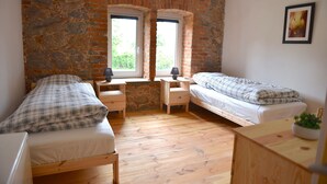 A room with two beds, a desk, and a window with a view. - Cozy accommodations on Lake Oberuckersee for larger groups (Flieth-Stegelitz)