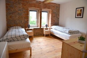 Ein Zimmer mit zwei Betten, einem Schreibtisch und einem Fenster mit Blick.