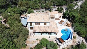 A large house with a swimming pool, surrounded by trees and rocky terrain. - Villa 'Carlini' with Sea View, Wi-Fi and Air Conditioning (Son Serralta)