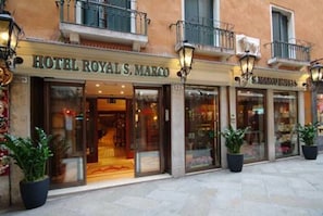 Eine Hotelsansicht mit der Aufschrift 'HOTEL ROYAL S. MARCO' und einem sichtbaren Eingang.