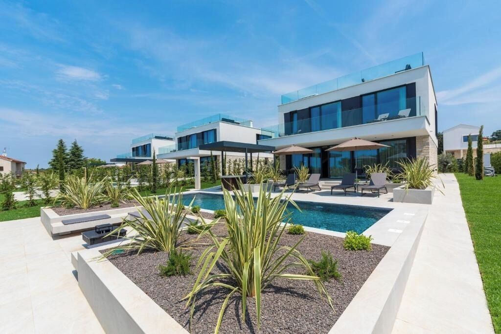 Ein moderner Wohnkomplex mit Schwimmbad, Außenbereich und gepflegtem Garten.