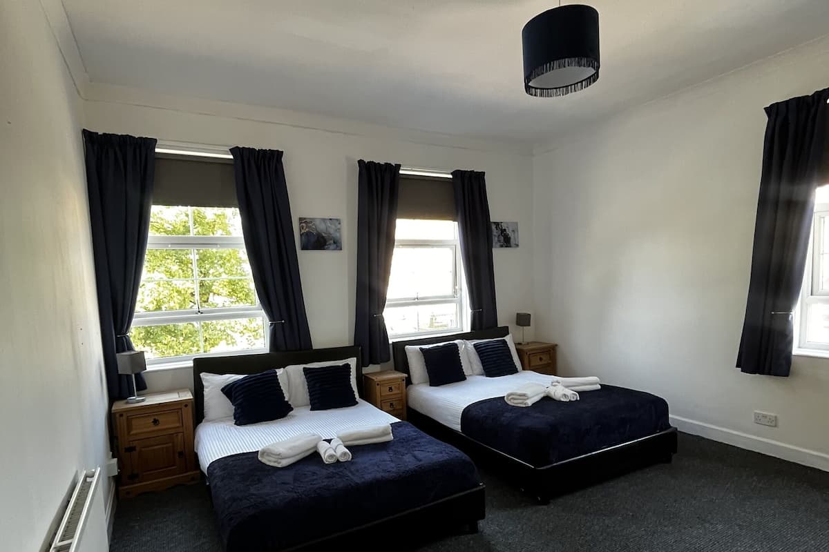 Escritorio, cortinas blackout y tabla de planchar con plancha
