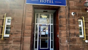A hotel entrance with a sign reading 'The Harbour Hotel.'