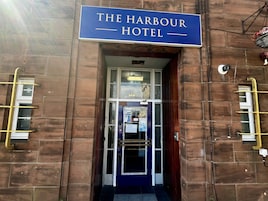 A hotel entrance with a sign reading 'The Harbour Hotel.'