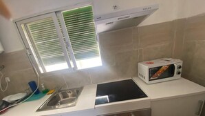 A kitchen with a built-in microwave, a sink, and a stove.