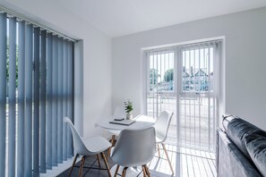 Ein modernes Zimmer mit Esstisch, Stühlen und einer Couch.
