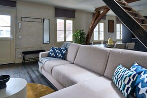 Ein Wohnzimmer mit Sofa, einer Bank, einem Couchtisch und einer Treppe.