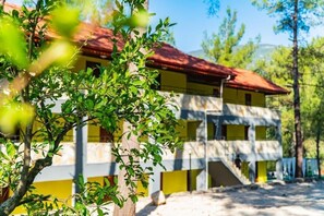 A two-story building with a red roof, surrounded by greenery. - Gökbük Serenity Hotel (Finike)
