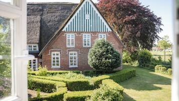 Ein traditionelles Haus mit steilem Satteldach, einer Ziegel-Fassade und Fenstern mit weißen Rahmen.