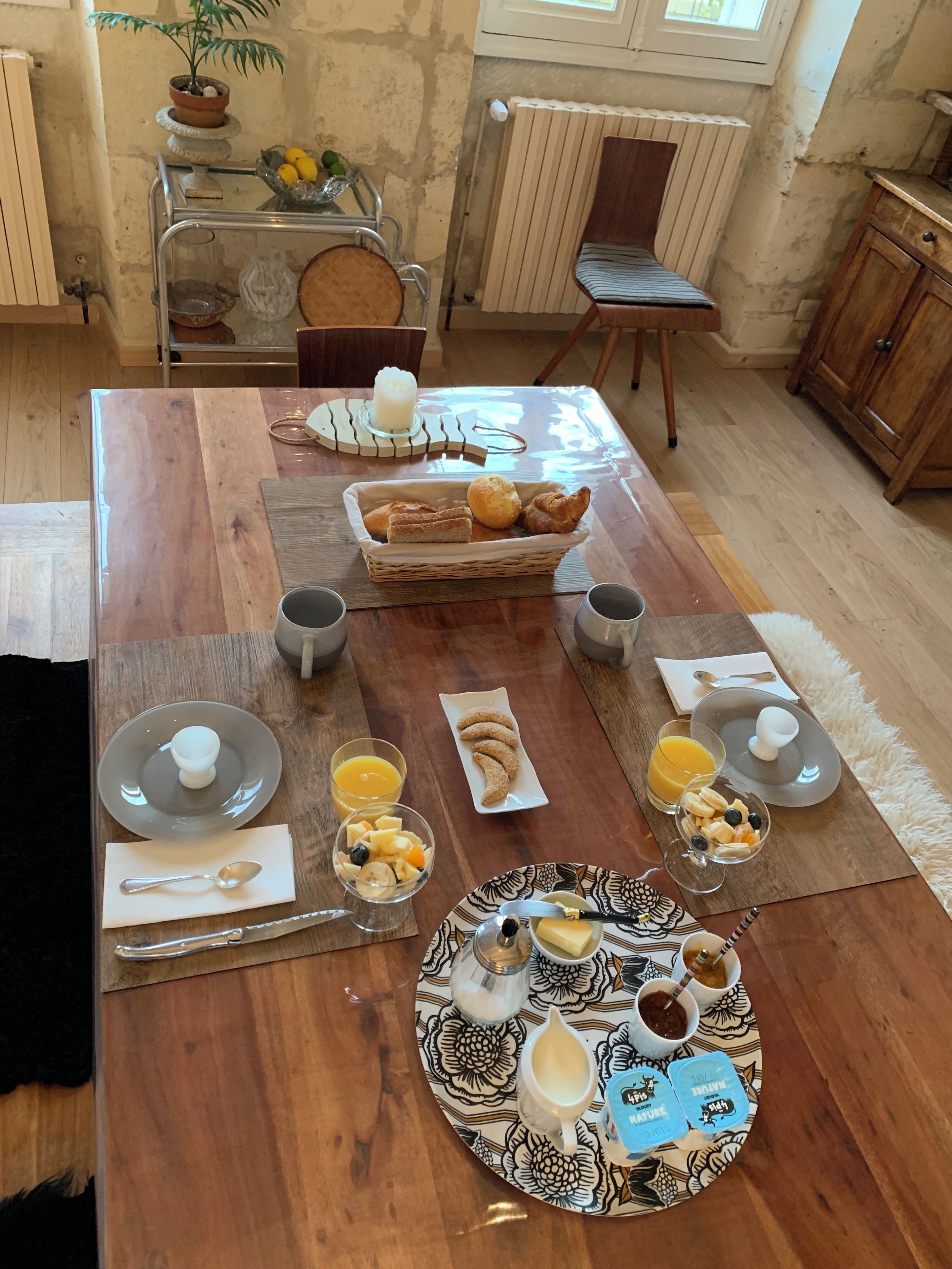 Ein Frühstückstisch mit Holzplatte, verschiedenen Speisen und rustikalem Ambiente.