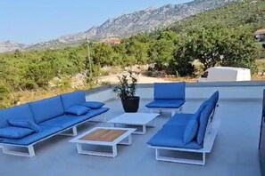 A rooftop terrace with blue outdoor furniture, a potted plant, and a view of mountains. - Seaview 8 Bed Villa Sleeps 16 - Pool & Hot tub (Starigrad)