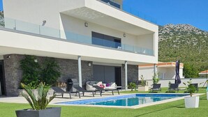 A modern two-story house with a swimming pool, outdoor seating, and a mountain backdrop. - Seaview 8 Bed Villa Sleeps 16 - Pool & Hot tub (Starigrad)