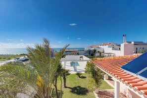 A coastal property with a swimming pool, a view of the sea, and a red-tiled roof. - Luxury Coastal Villa with Heated Pool,  Basketball Court & Ocean Views near Lisbon (Atalaia de Cima)