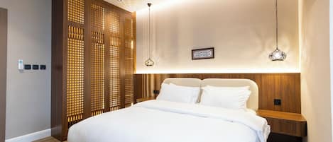 Un dormitorio moderno con una cama grande, cabecero de madera y un panel decorativo en la pared.